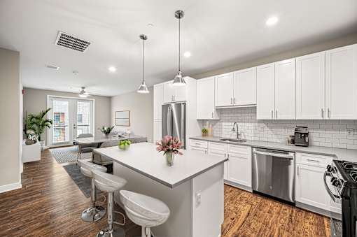 A modern kitchen with white cabinets and a center island.