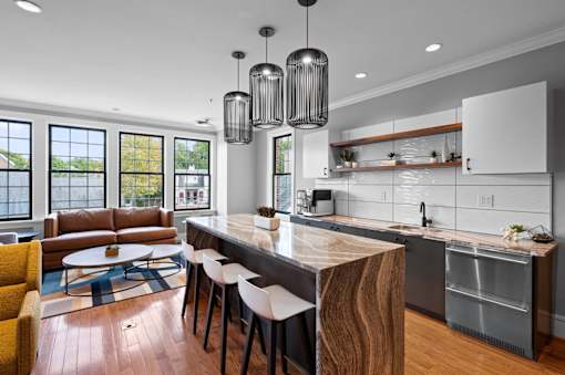 A modern kitchen with a wooden island and white cabinets.