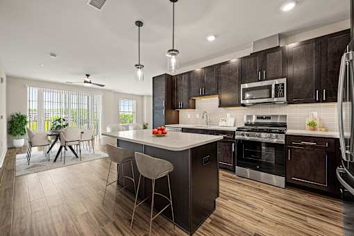 A modern kitchen with dark wood cabinets and a center island.