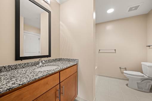 A bathroom with a sink, mirror, and toilet.