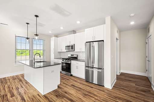 A modern kitchen with white cabinets and stainless steel appliances.