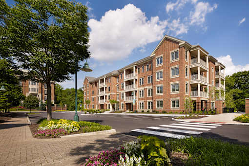 A large brick building with a green lawn in front.