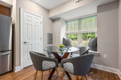 A kitchen with a table and chairs.