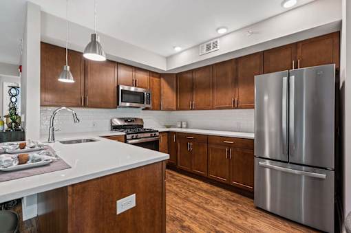 A modern kitchen with wooden cabinets and stainless steel appliances.