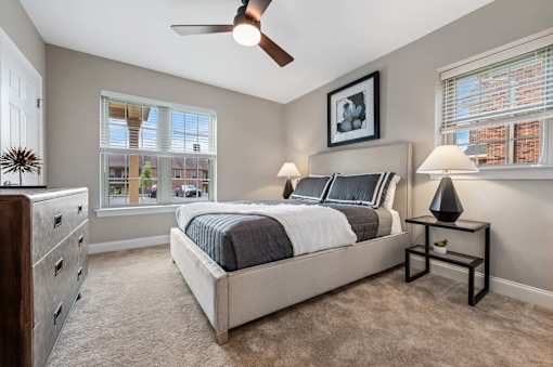 A bedroom with a bed, nightstand, and window.