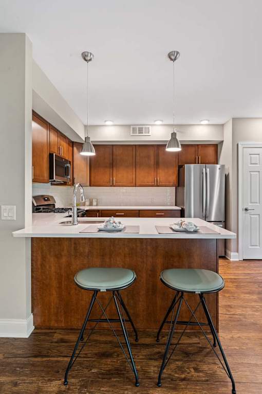 A kitchen with a white countertop and wooden cabinets.
