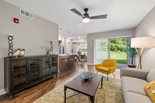 A living room with a yellow chair and a brown coffee table.