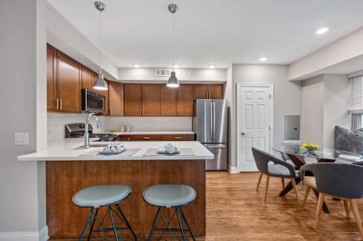 A kitchen with a bar stool and a dining table.