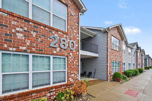 Northbrooke Commons exterior with multi-color brick, blue siding, beautiful landscaping and surface parking lot