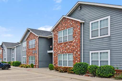 Northbrooke Commons exterior with multi-color brick, blue siding, beautiful landscaping and surface parking lot