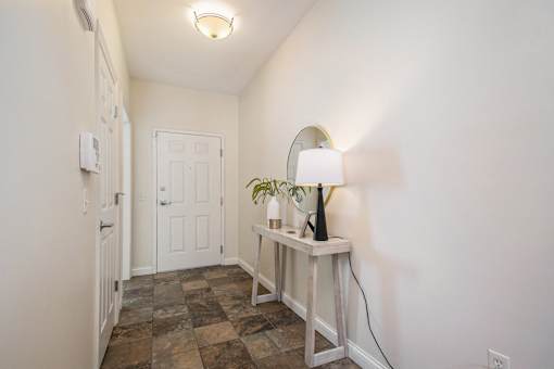 A lamp on a table in a room with a tiled floor.