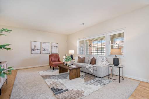 Living room with couch, coffee table, side tables and an accent chair.