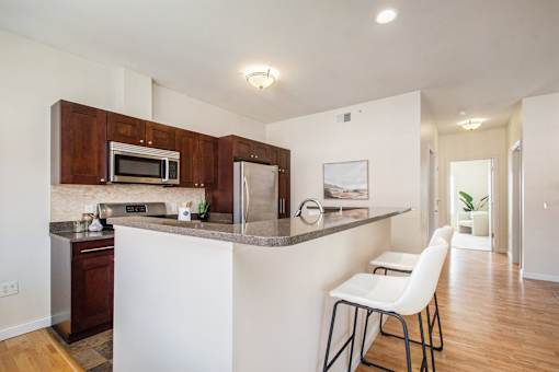 A kitchen with a white counter and brown cabinets.