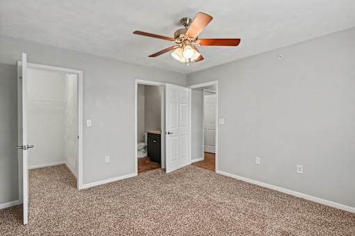 Northbrooke Commons bedroom with en suite bathroom, closets, ceiling fan and plush carpeting