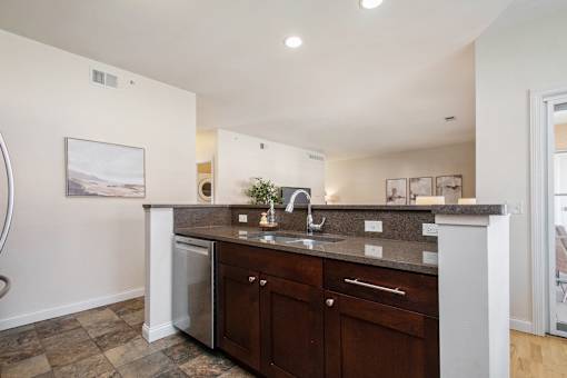 A kitchen with a white counter top and brown cabinets.
