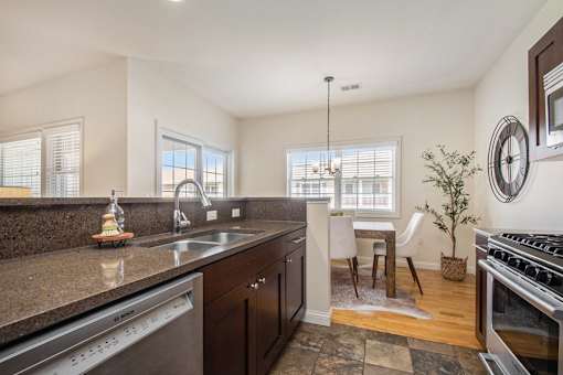 A kitchen with a dining table and chairs in the middle of the room.
