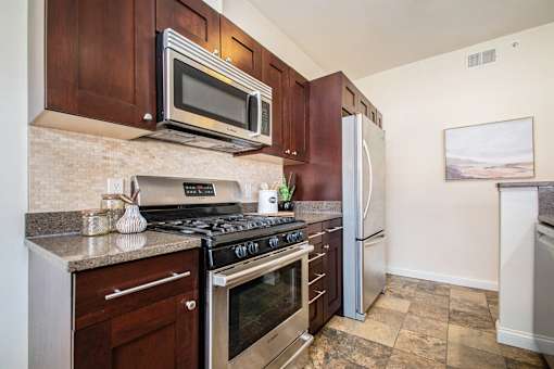 A kitchen with a stove top oven and a microwave above it.