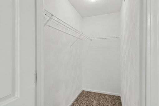 Northbrooke Commons walk-in closet with wire shelving and plush carpeting