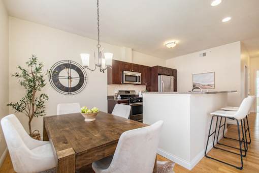 Kitchen and dining room view with dining table and chairs, and bar stools.