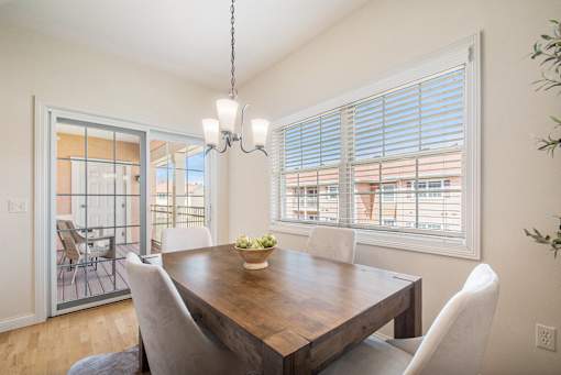 Dining room with table and chairs overlooking patio.