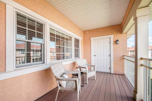 A balcony with a chair and a table.