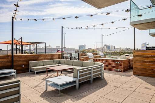 A patio with a table and chairs overlooking a cityscape. at One Foundry Way Apartments, St Louis, 63110