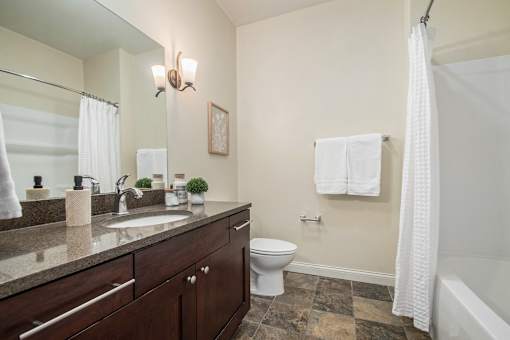 A bathroom with a toilet, sink, and a shower curtain.