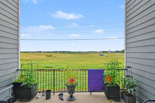 Northbrooke Commons breezeway with potted plants and flowers overlooking open field