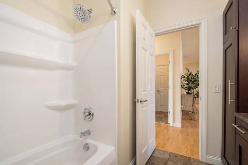 A white bathroom with a white tub and a white door.