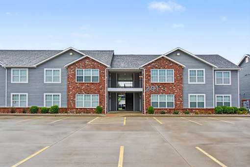 Northbrooke Commons exterior with multi-color brick, blue siding, beautiful landscaping and surface parking lot