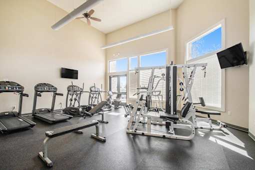 A gym with treadmills, exercise bikes, and weight machines.