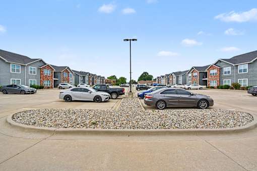 Northbrooke Commons exterior with multi-color brick, blue siding, beautiful landscaping and surface parking lot
