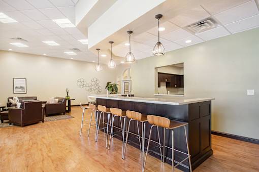 A modern kitchen with a bar area and seating.