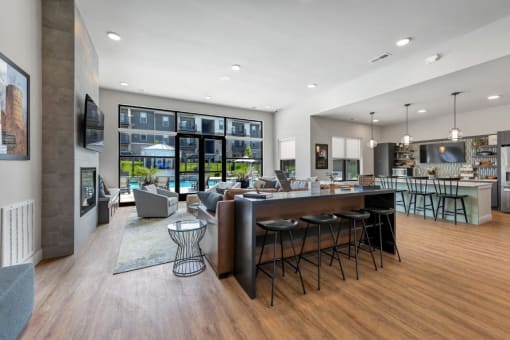 a living room with a bar and a kitchen at The Prairie Luxury Apartments, Dardenne Prairie, MO 63368