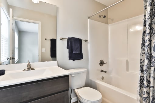 a bathroom with a sink toilet and shower and a mirror