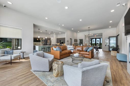 a living room with couches and chairs and a kitchen at The Prairie Luxury Apartments, Missouri, 63368