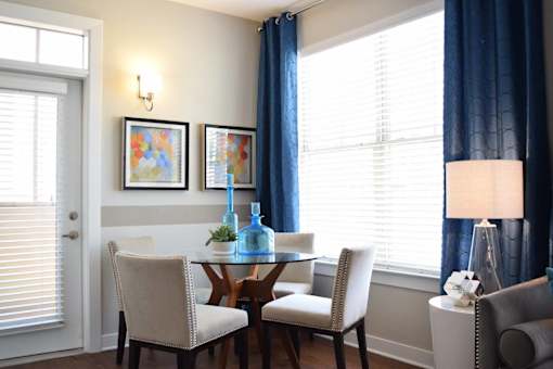 Dining nook with natural light and blue curtains at GrandView Flats and Townhomes Apartments, Granger, IN