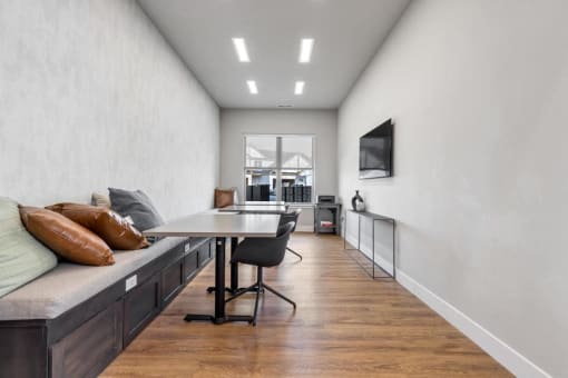 a dining room with a table and chairs and a wall mounted tv at The Prairie Luxury Apartments, Missouri, 63368
