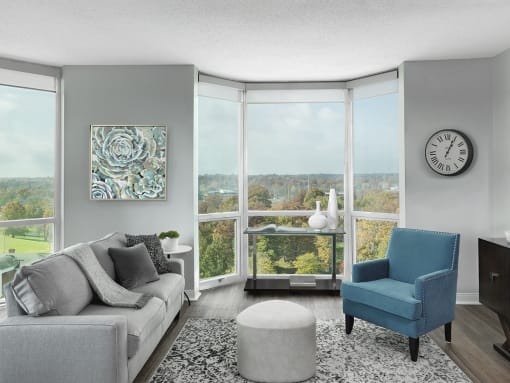 Apartment living room with modern sofa, side chair and floor-to-ceiling window  at Clayton On The Park, Clayton, MO