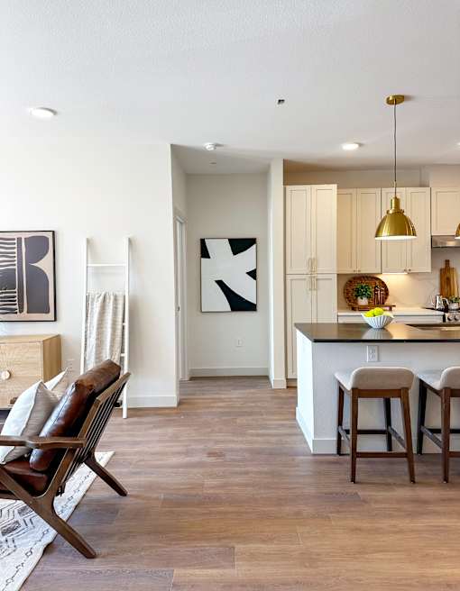 A kitchen with a bar and chairs.