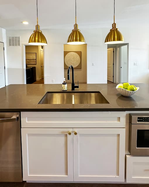 A kitchen with a sink, stove, and refrigerator.