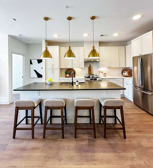 A kitchen with a bar and stools.