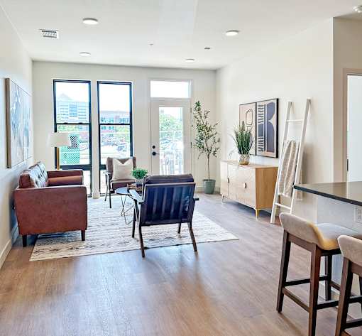A living room with a brown chair and a blue chair in the middle of the room.