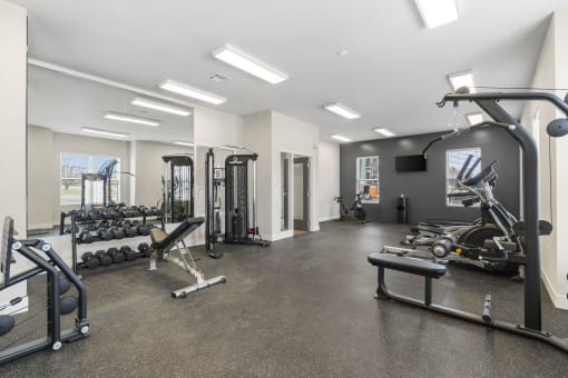 the gym is equipped with weights and cardio equipment at the flats at west end apartments at The Junction at Rogers, Rogers, AR