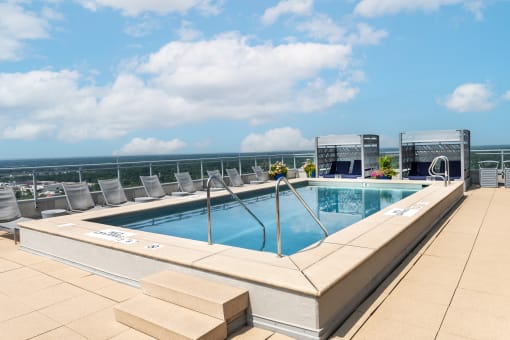 the pool on the rooftop of a hotel with chairs and the ocean in the background at Two Twelve Clayton, Clayton, MO
