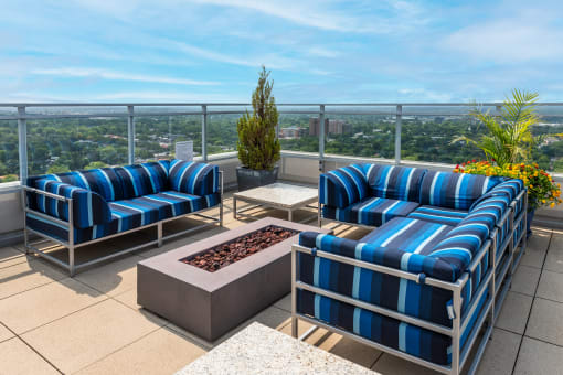 a balcony with blue and white chairs and a fire pit at Two Twelve Clayton, Clayton, MO