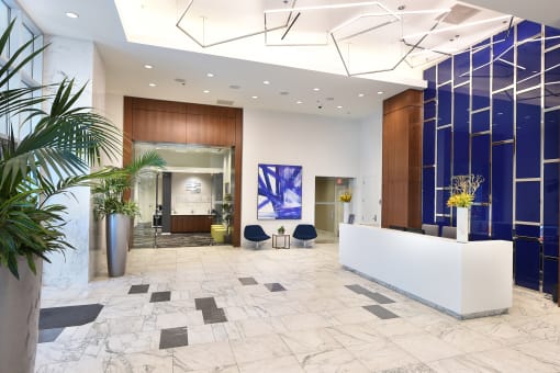 lobby with marble floors and cobalt blue wall behind concierge desk  at Two Twelve Clayton, Missouri, 63105
