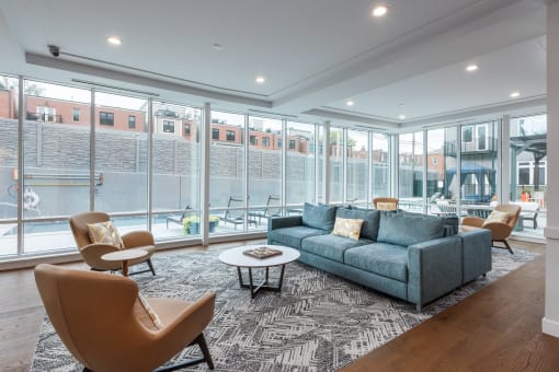 a living room with a couch and chairs and large windows at 2200 LaSalle Apartments, St Louis, MO