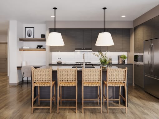 a kitchen with a large island and chairs in front of a table at Bemiston Place Apartments, Clayton Missouri