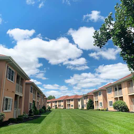 A row of apartment buildings with green lawns in front.